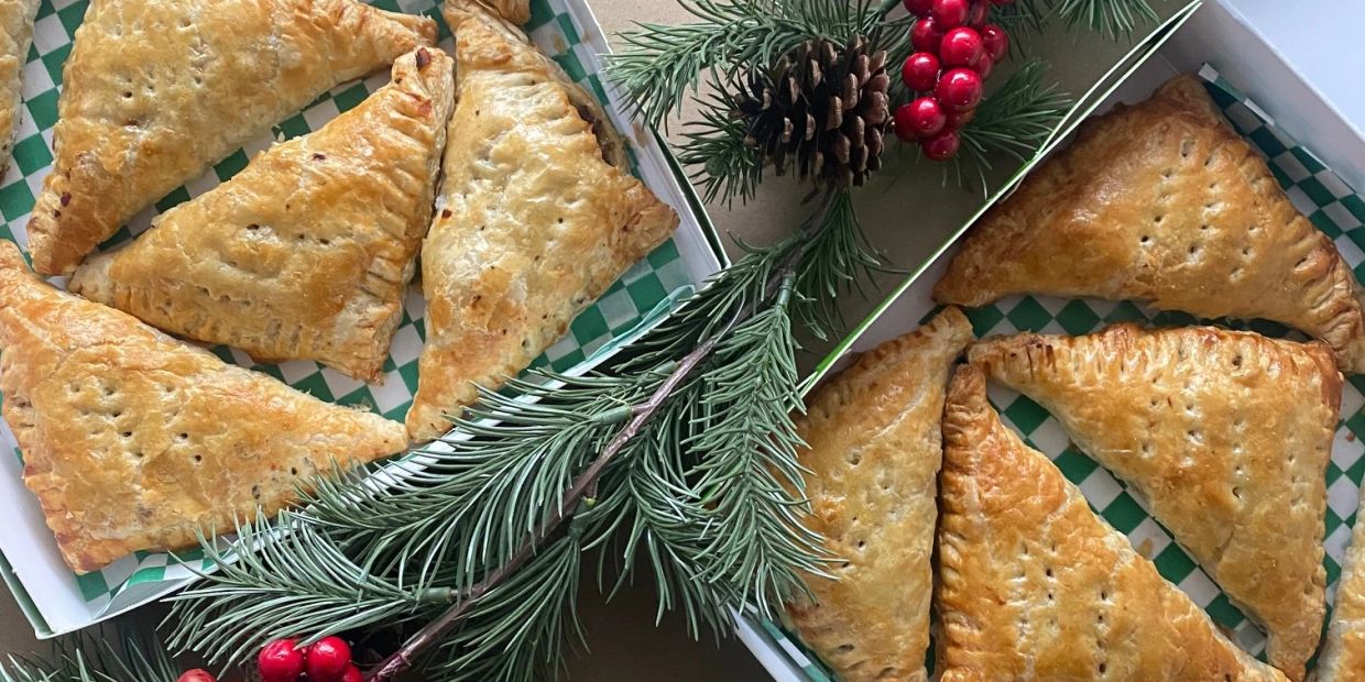 Boxes of triangular pastries with festive decorations.