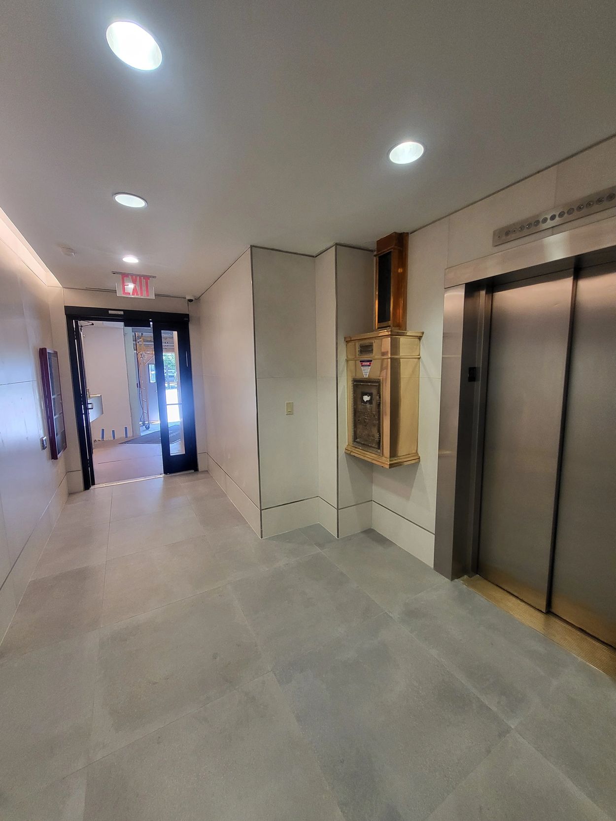 Modern lobby with elevator and exit door.