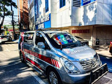 A silver ambulance parked outside Saint Paul Doctors Hospital's emergency entrance.