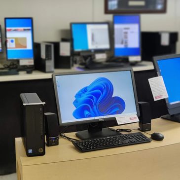 refurbished desktop computers on display in a store