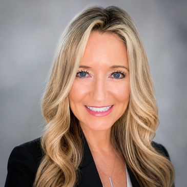 Professional headshot of a smiling blonde woman with blue eyes.