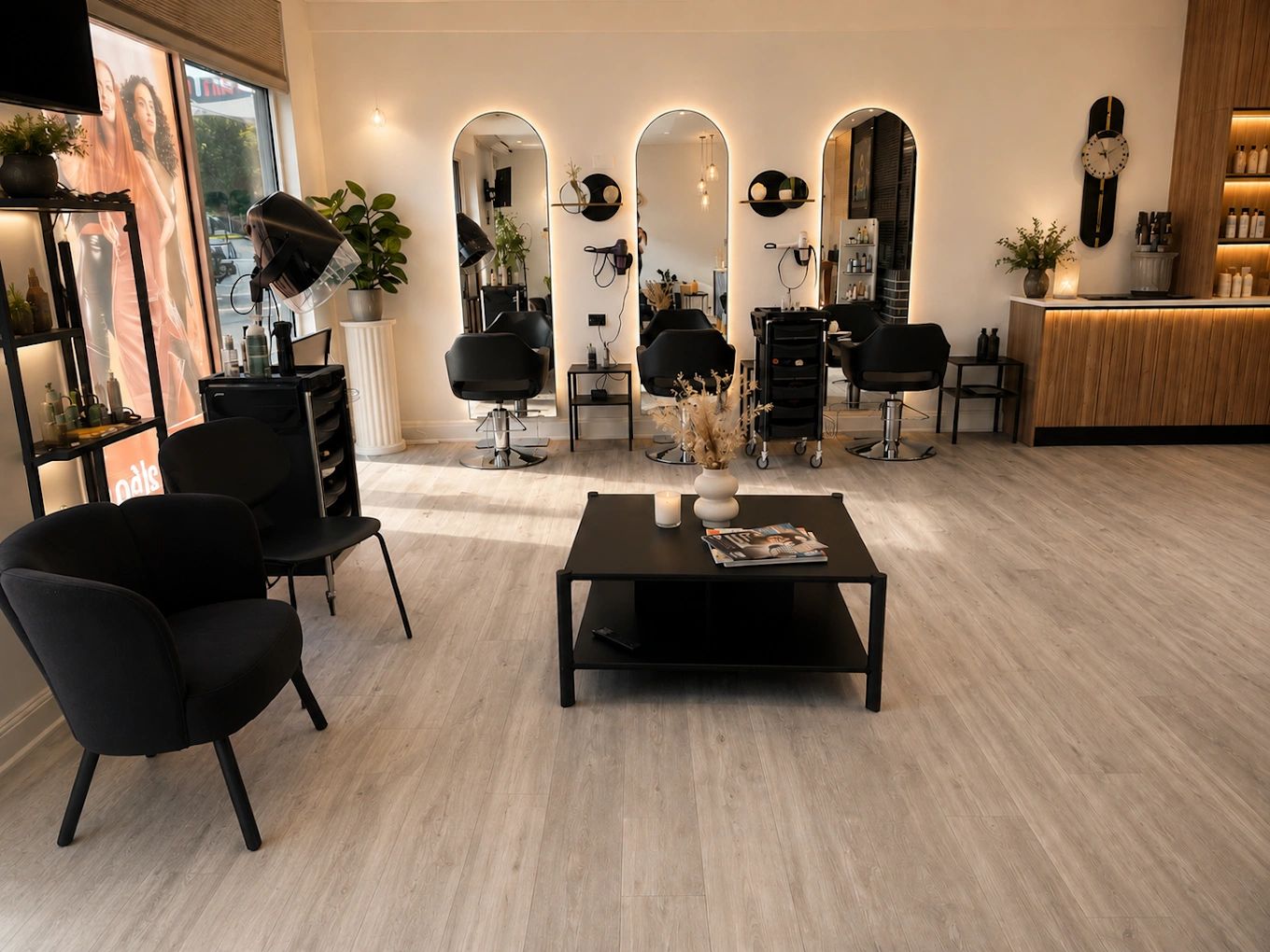 Modern hair salon with stylish black chairs and warm lighting.