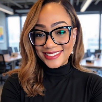 Smiling woman with glasses in an office.