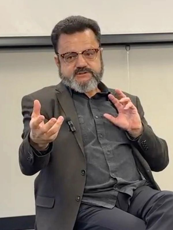 Man with glasses and beard speaking.