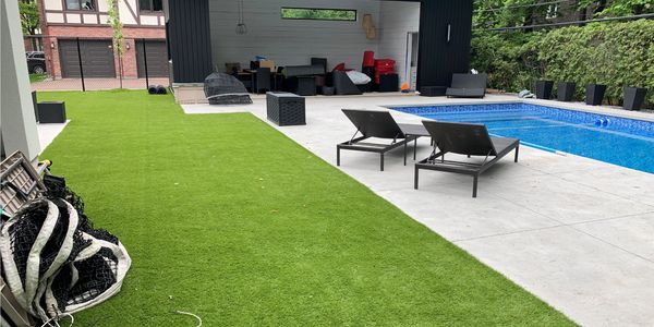 terrasse en gazon artificiel à côté de la piscine