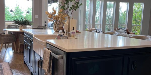 Modern kitchen island with dark cabinetry and pendant lights.