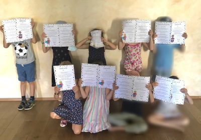 Kinder zeigen ihre Urkunden.