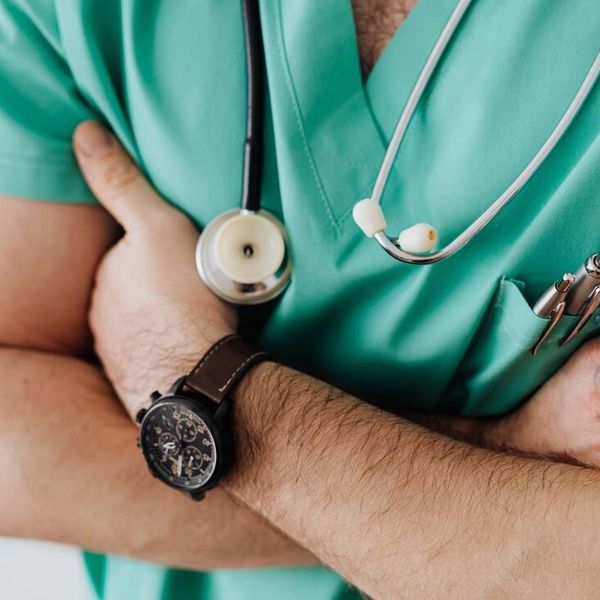 doctor wearing scrubs with arms crossed