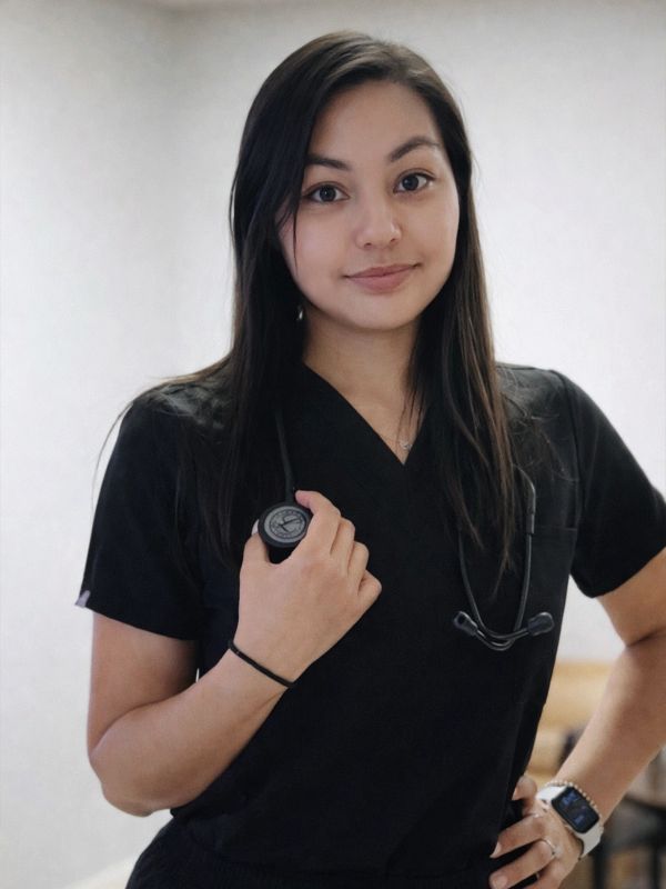 Female healthcare professional in black scrubs with stethoscope.