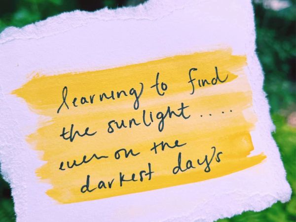 Handwritten inspirational quote on yellow paint.
