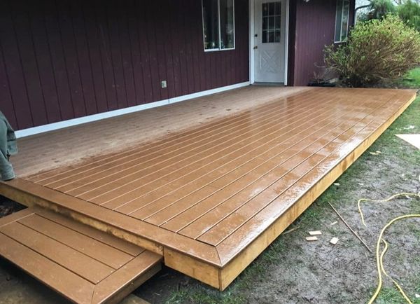 Newly built wooden deck attached to a house with a small step.