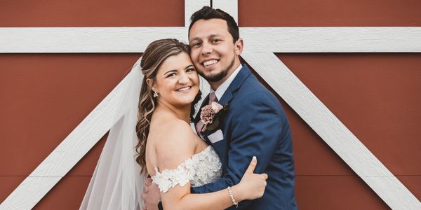 This heartwarming photo captures a joyous newlywed couple embracing and smiling brightly.