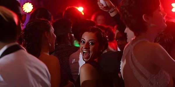 A guest caught mid-scream of pure excitement on a vibrant, red-lit dance floor!