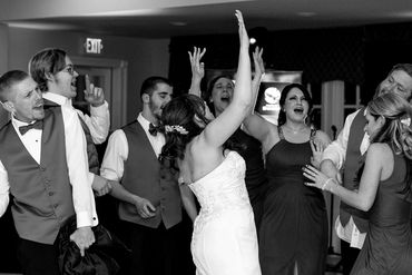 The bride and her guests throwing their hands up in genuine delight.