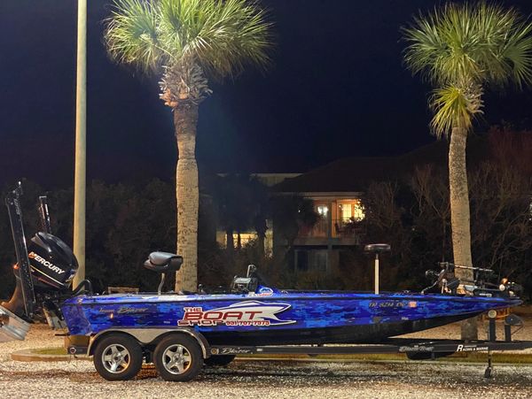 Blue fishing boat on a trailer at night.