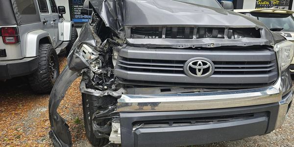 Front-end damage on a gray Toyota truck after a collision.