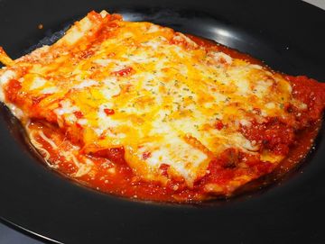a plate with a huge serving of lasagna dusted with parmesan and parsley