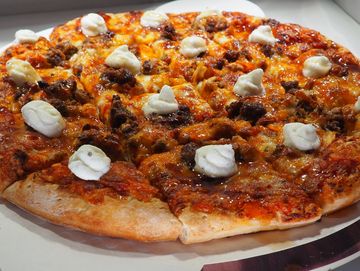 pizza with red sauce, cheese blend, sausage, beef, ham and ricotta cheese dollops.
