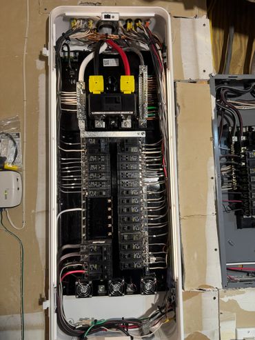 Open electrical breaker panel with organized wiring and labeled breakers.