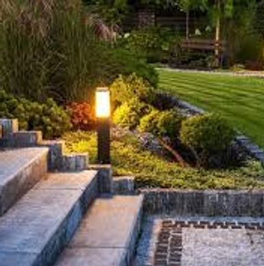 Illuminated stone steps leading to a garden at night.