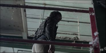 Person wearing tactical gear in an industrial setting.