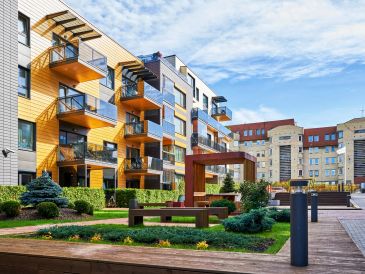 Modern apartment buildings with balconies and landscaped garden.
