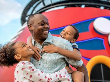 Father joyfully hugging his two children.