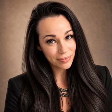 Woman with long dark hair smiling.