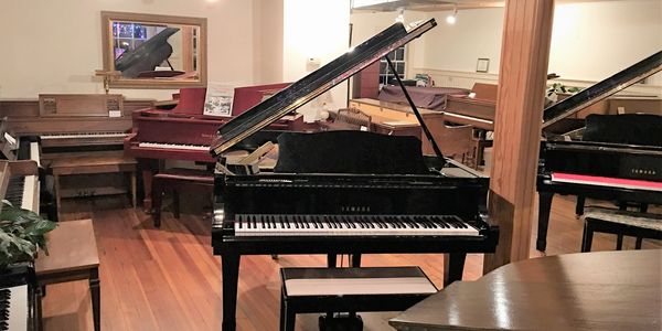 Bay State Piano showroom with various pianos on display