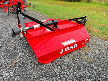 A red J BAR rotary mower attachment on gravel ground.