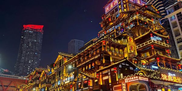 Vibrant illuminated traditional-style buildings against a night cityscape.