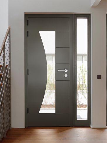 Modern dark front door with curved glass panel.