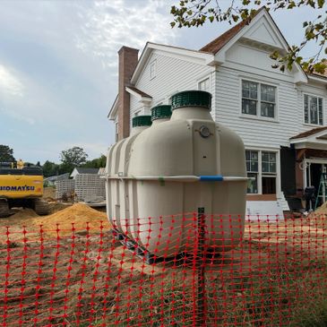 Large septic tank installed near a white house under construction.