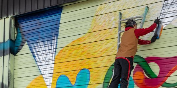 Colorful mural being live painted.