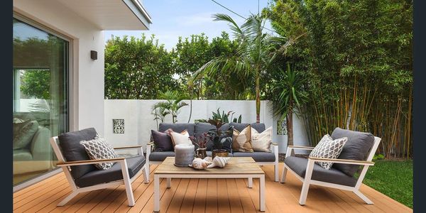 Outdoor deck and entertaining area with seating and lush tropical garden