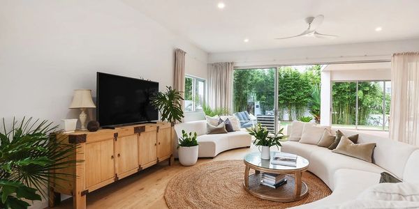 Living and entertaining area with with sliding doors, lots of natural light and natural finishes