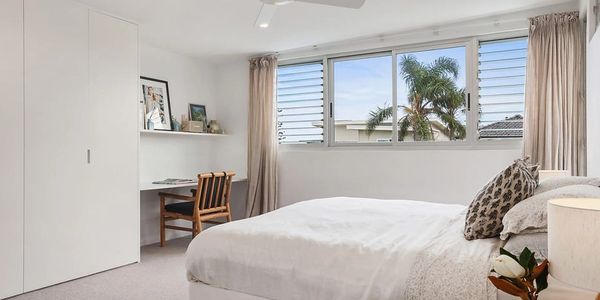 Guest bedroom with custom white robes and built in desk area
