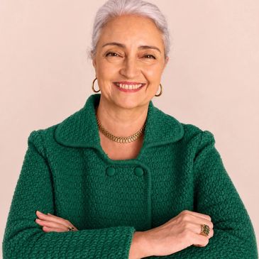 Mulher madura sorridente com casaco verde.