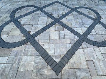 Intricate black brick pattern on a light gray tiled floor.