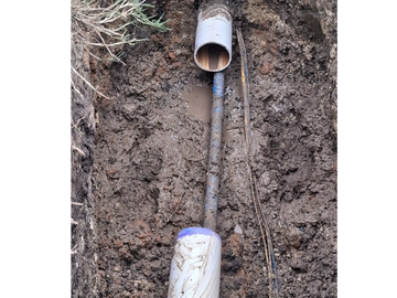 Installation of underground pipes in muddy soil.