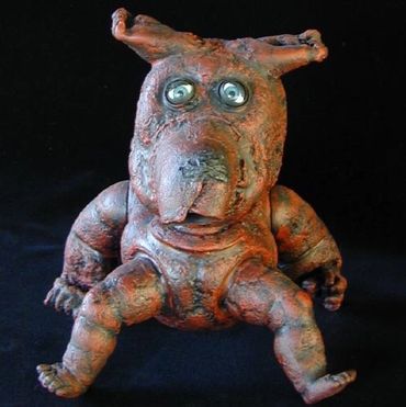 Red dog.  Plastic doll parts, fire, adhesive, paint.