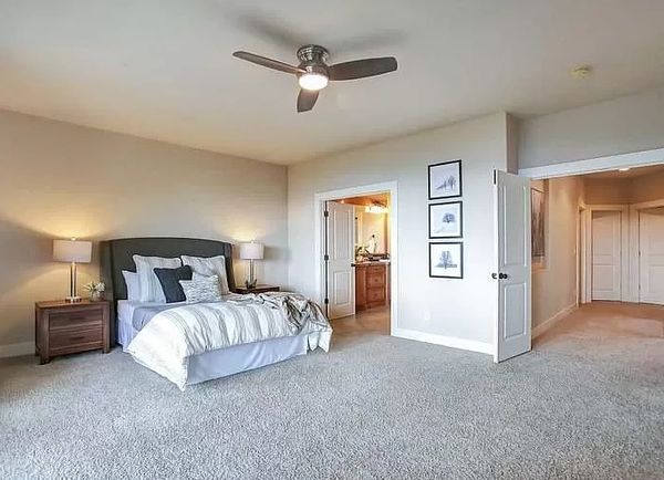 Large furnished primary bedroom with new carpet.
