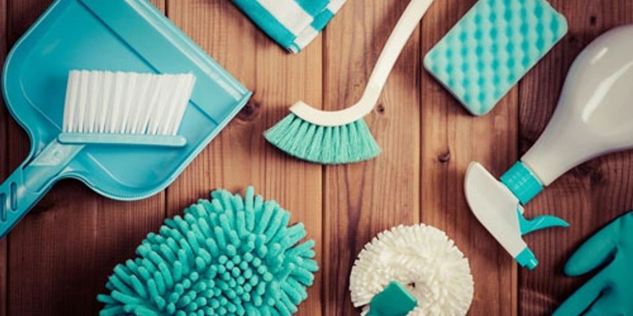 Cleaning tools and supplies on a wooden surface.