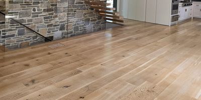Modern interior with floating wooden stairs and stone wall.