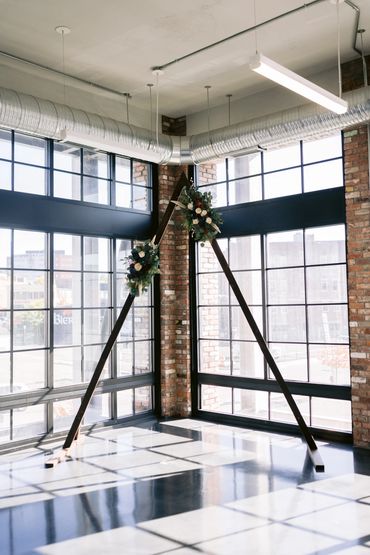 Beautiful wooden arbor adorned with colorful wood flowers for a rustic wedding look