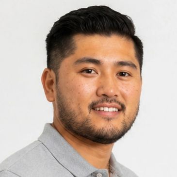 Portrait of a smiling man with neatly styled hair and a trimmed beard.