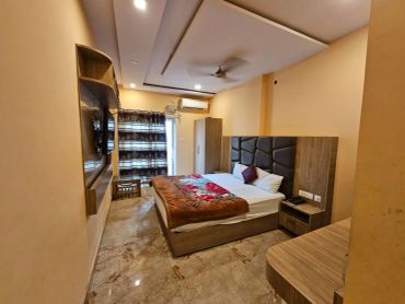 Cozy bedroom with a large bed, wooden furniture, and a ceiling fan.