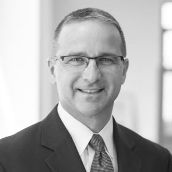 Middle-aged man in suit smiling.