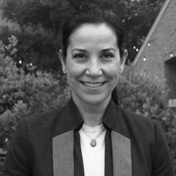 Smiling woman outdoors in black and white portrait.