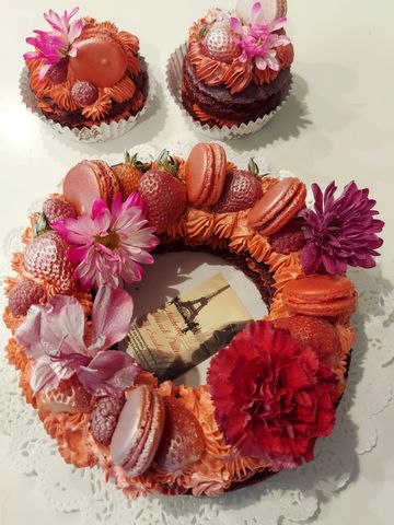 Red velvet cake, wrapped in whipped cream velvet flavored, topped with fresh berries, macarons and f